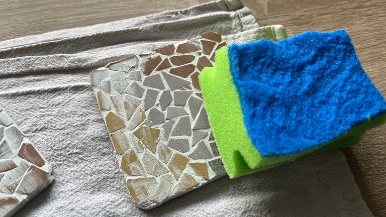 Mit einem feuchten Tuch oder Schwamm können die Reste nach der Trocknung ganz einfach abgetragen werden. 