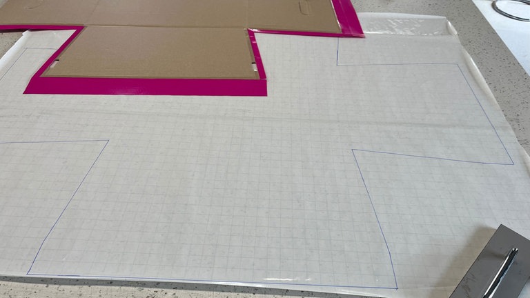 Der Zuschnitt wird aufgelegt. Mit einem permanenten Folienstift werden die Umrisse des Schnittmusters auf die Folie übertragen. 