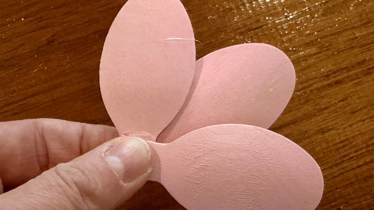 Hierbei sollte ein Löffelblatt unten sein und die beiden anderen rechts und links darüber liegen. 