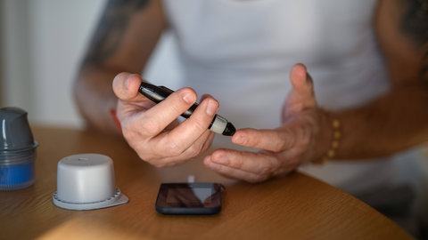 Mann mit Diabetes. Bei Erwachsenen können belastende Erfahrungen aus der Kindheit nicht nur psychische, sondern auch körperliche Erkrankungen wie Diabetes zur Folge haben.