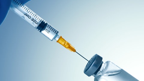 Symbolbild - aus einer Glasampulle wird eine durchsichtige Flüssigkeit in eine Spritze aufgezogen. Gentherapie wird die Krankenkassen in Zukunft mit mehreren Millionen Euro belasten.