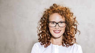Rothaarige Frau mit Locken und Sommersprossen
