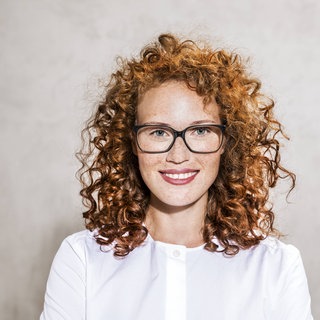 Rothaarige Frau mit Locken und Sommersprossen