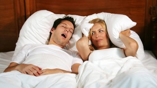 Ein Mann schnarcht, die Frau ist genervt. Schlafapnoe, also Schnachen mit Atemaussetzern, gehört zu den häufigsten Schlafstörungen