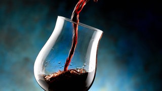 Rotwein wird in ein Glas gegossen