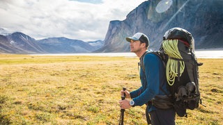 Backpacker mit schwerem Rucksack vor Bergpanorama in Kanada: Wenn man die Schultern zu stark belastet, reagiert die Muskulatur darauf – in der Regel mit Verspannungen, aber auch mit Druckschmerzen. Die entstehen durch die Belastung der Träger; die rufen Druckstellen hervor. 