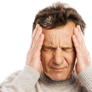 Mann hält sich Hände an den Kopf