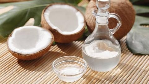 Kokosnüsse und eine Flasche mit Kokosöl