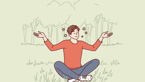 Mann sitzt glücklich im Lotussitz auf dem Rasen. Hoffnung ist laut einer neuen Studie der wichtigste Faktor für das Empfinden von Lebenssinn.