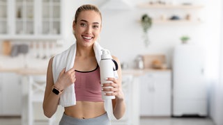 Frau mit Handtuch und Trinkflasche