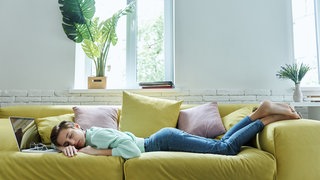 Frau schläft auf der Couch