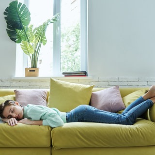 Frau schläft auf der Couch