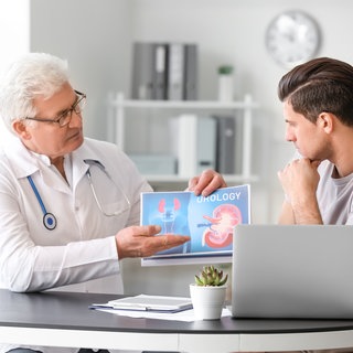 Arzt erklärt einem Mann etwas zur Prostata Vorsorge