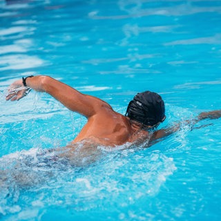 Mann schwimmt im Schwimmbecken