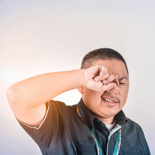 Ein Mann reibt sich am Auge. Bei Durchblutungsstörungen im Auge sind eine schnelle Diagnose und das sofortige Aufsuchen eines Arztes wichtig. Denn die Folgen können gravierend sein - bis zur Erblindung. 
