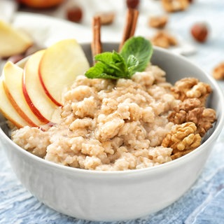 Haferkleie, Porridge oder gekochte Haferflocken mit Apfel, Walnüssen und Honig