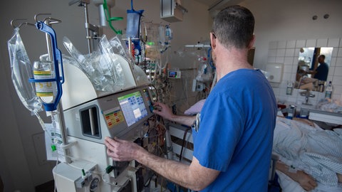 Ein Arzt bedient ein Dialysegerät auf einer Intensivstation.