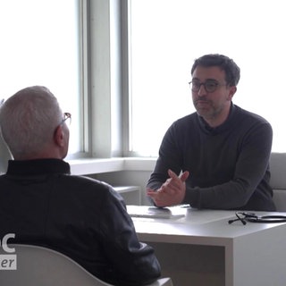 Arzt mit Patient im Gespräch am Schreibtisch