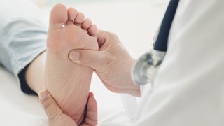 Fuß wird von einem Arzt massiert