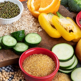 Gesunde Nahrungsmittel wie Gemüse, Vollkornbrot, Hülsenfrüchte, Saaten, Obst auf einem Tisch. Neue Studien zeigen: Unsere Ernährung hat weitreichende Folgen für die Gesundheit – stärker als bislang gedacht. Sie kann chronische Entzündungen, Diabetes oder Herzerkrankungen fördern. Doch eine ausgewogene Ernährung mit Ballaststoffen, Gemüse und Proteinen kann viele Risiken mindern.