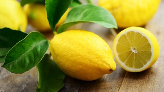 Zitrone mit Blättern und halbe Zitrone