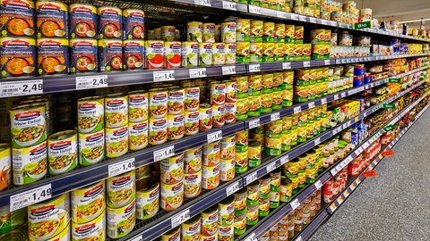 Konservendosen im Regal eines Supermarktes:Schädliches Bisphenol kann aus der Dosenbeschichtung in den Inhalt übergehen, warnt Stiftung Warentest.
