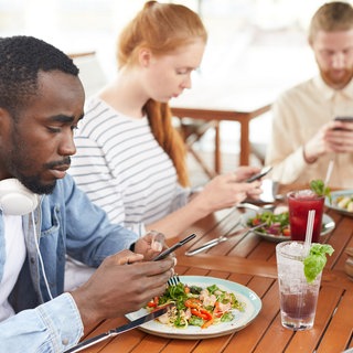 am Tisch mit Smartphone, Essen Tracken