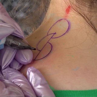 Jemand bekommt ein Tribal tätowiert