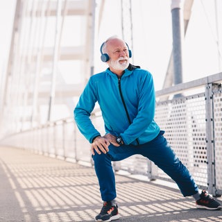 Mann macht Sport und hält sein Knie