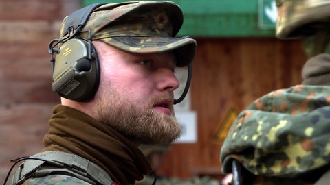 Bundeswehr-Soldat trägt Tarnkleidung und Kopfhörer