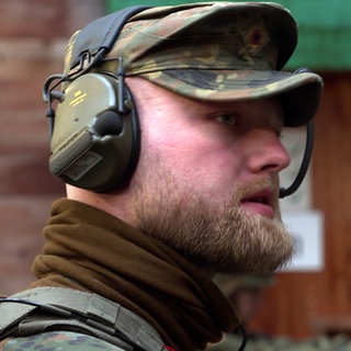 Bundeswehr-Soldat trägt Tarnkleidung und Kopfhörer