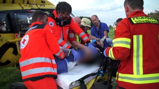 Rettungskräfte kümmern sich um einen schwer verletzten Motorradfahrer