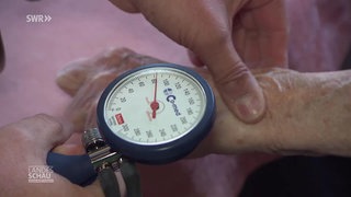 Ein Arzt misst den Blutdruck bei einer Patientin