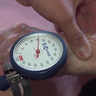 Ein Arzt misst den Blutdruck bei einer Patientin