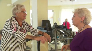 Fitnessstudiobetreiberin Sabine mit Seniorin beim Training