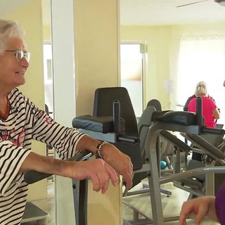 Fitnessstudiobetreiberin Sabine mit Seniorin beim Training