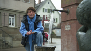 Sonja Faber-Schrecklein steht am Dorfbrunnern von Sulzbach-Laufen