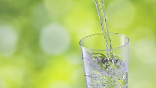 Ein Glas Wasser wird eingegossen
