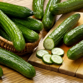 Frische Salatgurken im Korb und auf Schneidebrett | Darum sind Gurken so gesund