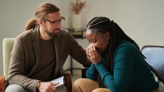 Eine Frau lässt sich in der Psychotherapie trösten | So kann Psychotherapie bei Depressionen helfen