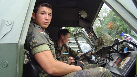 Hagen bei seinem ersten Einsatz im Kosovo. Er sitzt mit Tarnkleidung in einem gepanzerten Fahrzeug und schaut in die Kamera. SWR1 Neuanfang - Hagen: Weiterleben mit dem Kriegstrauma. Hagen Vockerodt aus einem Dorf bei Ehingen war als Soldat an fast allen Krisenorten dieser Welt. 1638 Tage Krieg haben ihn traumatisiert, aber nicht gebrochen. In "SWR1 Neuanfang" erzählt er offen über Einsätze, Ängste, PTBS und seine jahrelange Therapie.
