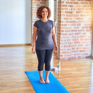 Frau steht auf Matte