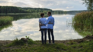 Paar steht vor einem See. | Psychologin Antonia Lutterbach über Achtsamkeit: So wird der Moment unvergesslich