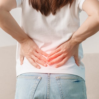 Frau hat Schmerzen im unteren Rücken