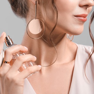 Frau trägt Parfüm auf