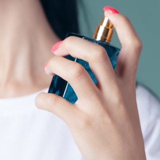 Frau trägt Parfüm auf