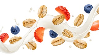 Haferflocken auf einem Milchstrahl mit Heidelbeeren und Erdbeeren: Haferflocken enthalten Phytinsäure und die hat einen Einfluss auf die Nährstoffaufnahme. Daher sollte man Haferflocken in Wasser oder Milch einweichen. Was passiert da genau im Körper bzw. im Dünndarm?