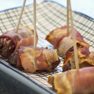 Datteln im Speckmantel auf einem Teller