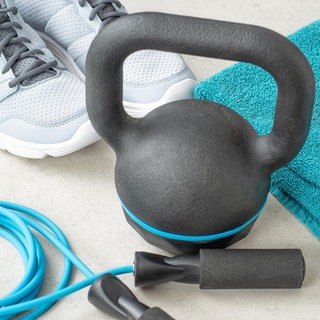 Sportschuhe, ein Springseil, eine Hantel und ein Apfel liegen nebeneinander | Gute Vorsätze sind oft zu groß | Neujahrsvorsätze: Mit realistischen Zielen motiviert ins neue Jahr