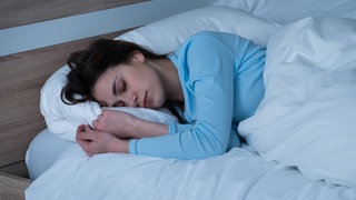 Frau schläft im Bett. Im Schlaf entstehen viele Daten. Diese Daten könnten mithilfe von KI in Schlafanalysen zur Vorhersage bestimmter Krankheiten genutzt werden.